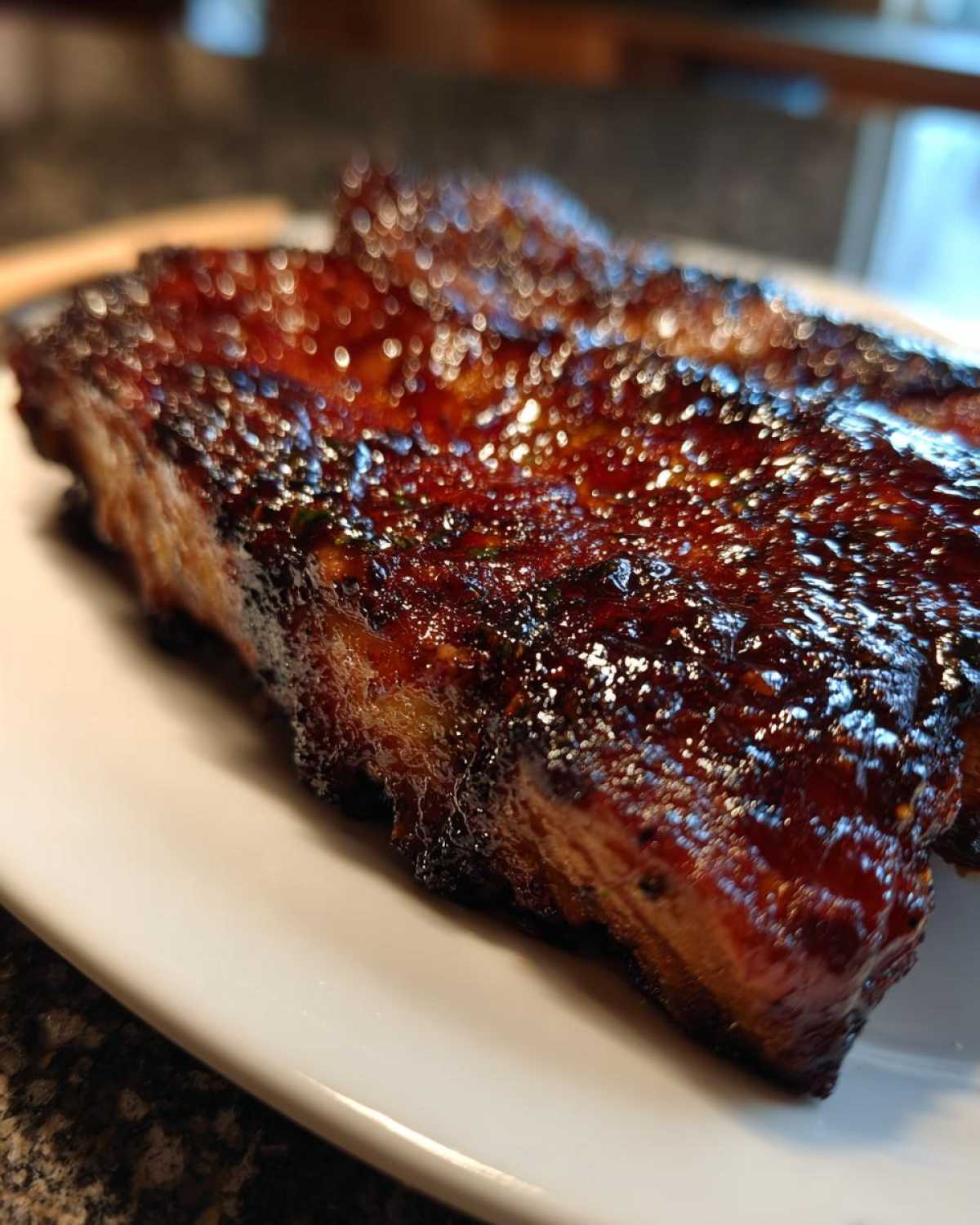 Close-up of a thick, juicy pork steak recipe cut, covered in a dark, glossy barbecue glaze.