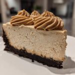 A close-up of a perfect slice of biscoff cheesecake featuring a dark crust and piped Biscoff topping.