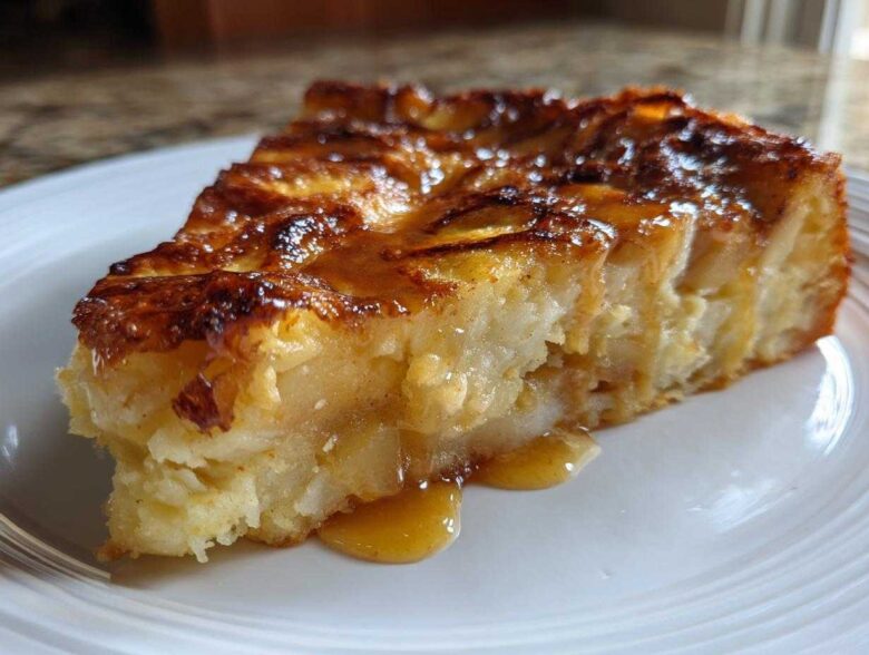 Close-up of a rich, gooey slice of caramel apple dump cake drizzled with caramel sauce.