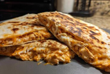 Close-up of golden brown Chicken Quesadillas cut into wedges, showing melted cheese and shredded chicken filling.