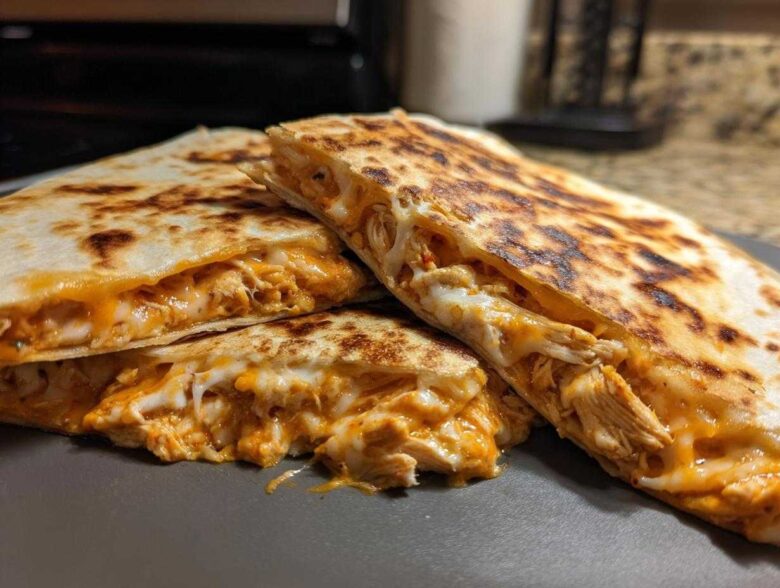 Close-up of golden brown Chicken Quesadillas cut into wedges, showing melted cheese and shredded chicken filling.