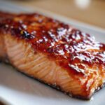 Close-up of a perfectly cooked fillet of Baked Salmon with Sweet and Savory Glaze, featuring a shiny, caramelized topping.