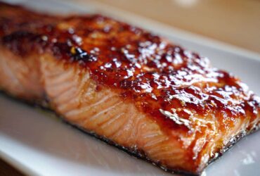 Close-up of a perfectly cooked fillet of Baked Salmon with Sweet and Savory Glaze, featuring a shiny, caramelized topping.