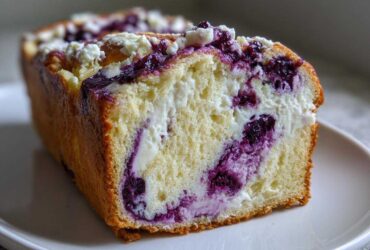 Cross-section view of a rich Blueberry Cream Cheese Bread Loaf showing swirls of cream cheese and blueberries in the moist crumb.