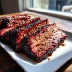 Close-up of tender, sliced Brisket in Slow Cooker, showing a dark bark and vibrant pink smoke ring.