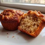 Close-up of a Brown Sugar Banana Muffin cut in half showing its moist, fluffy interior texture.