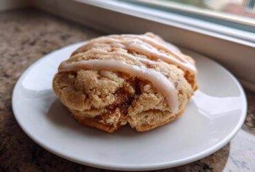 A single, thick Brown Sugar Pop Tart Cookie topped with a light brown sugar glaze, resting on a white plate.