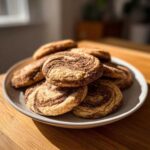 A plate piled high with freshly baked Coffee Marble Cookies showing distinct brown coffee swirls.