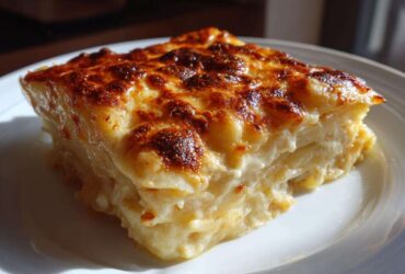A square slice of rich, layered Creamy Cheesy Scalloped Potatoes Made 1 with a golden-brown, bubbly cheese crust.