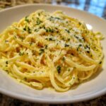 Close-up of a bowl of rich Creamy Lemon Pasta tossed in sauce, topped with grated Parmesan and fresh parsley.