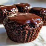 Close-up of a rich Espresso Brownie Cupcake topped with glossy, melted chocolate ganache.