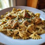A close-up of Garlic Butter Chicken Bowtie Pasta served in a creamy sauce, topped with herbs and Parmesan cheese.