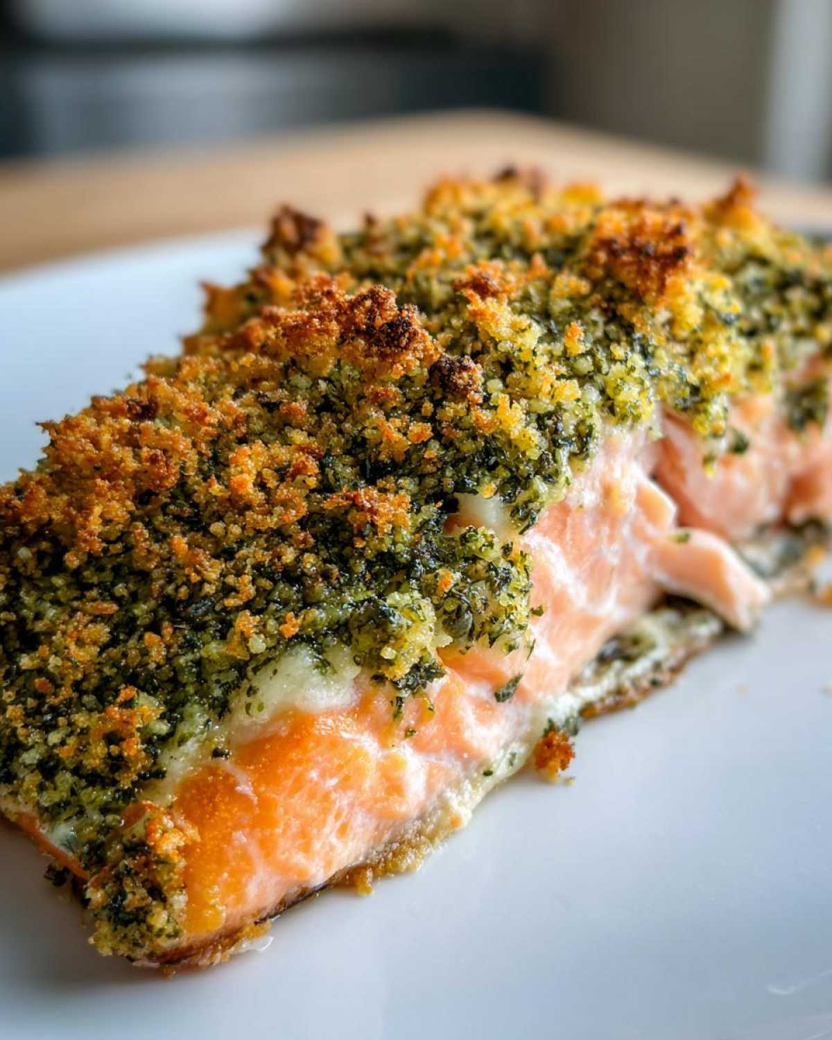 A close-up of a perfectly cooked piece of Herb-Crusted Baked Salmon with a golden, crunchy herb topping.