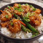 Close-up of a Honey Garlic Shrimp Bowls serving with glazed shrimp, white rice, green beans, and sesame seeds.