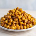A close-up of a mound of crispy Lemon Parmesan Roasted Chickpeas topped with bright yellow lemon zest.