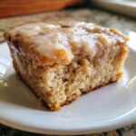 Close-up of a single serving of Moist Banana Bars with Browned Butter Vanilla Glaze on a white plate.