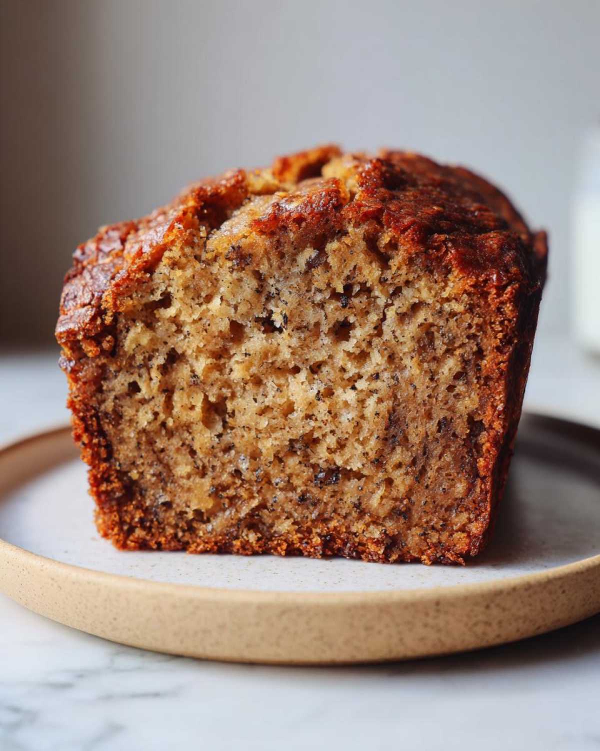 Close-up of a moist slice of homemade Banana Bread showing its rich texture and dark banana specks.