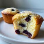 Close-up of a Moist and Fluffy Blueberry Muffin cut in half showing the soft crumb and juicy blueberries.