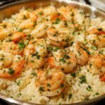 Close-up of One-Pan Garlic Shrimp and Rice garnished with parsley in a stainless steel skillet.