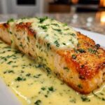 A beautifully seared fillet of salmon topped with rich lemon cream sauce and fresh parsley.