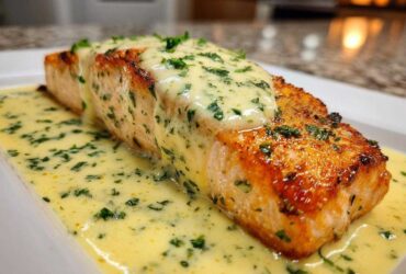 A beautifully seared fillet of salmon topped with rich lemon cream sauce and fresh parsley.