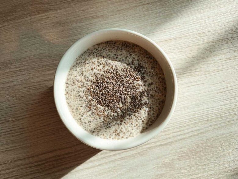 Overhead view of a white bowl filled with creamy Chia Seed Pudding, topped with extra chia seeds.